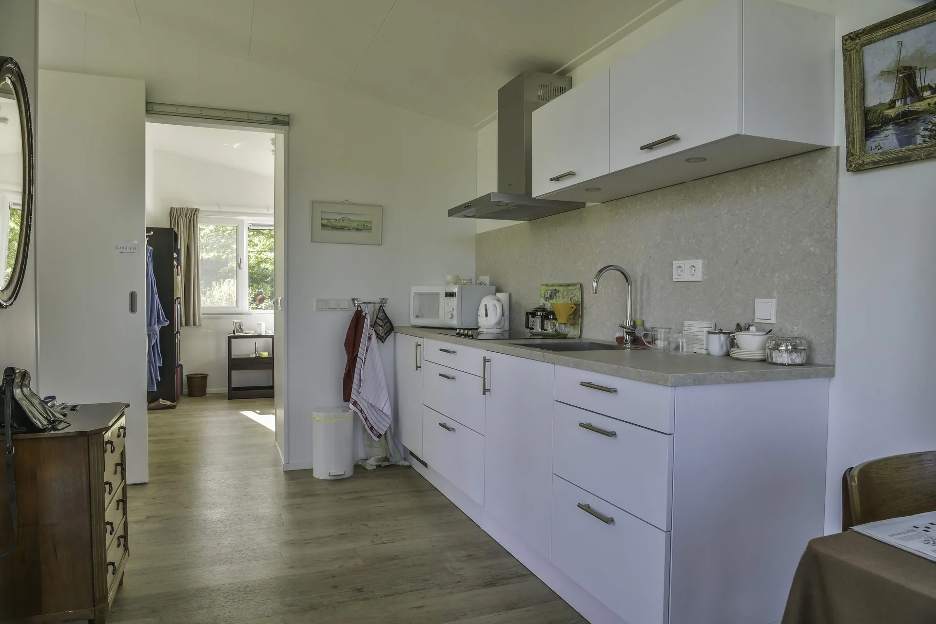Brede doorgang met schuifdeur tussen keuken en slaapkamer — geschikt voor rolstoel of rollator